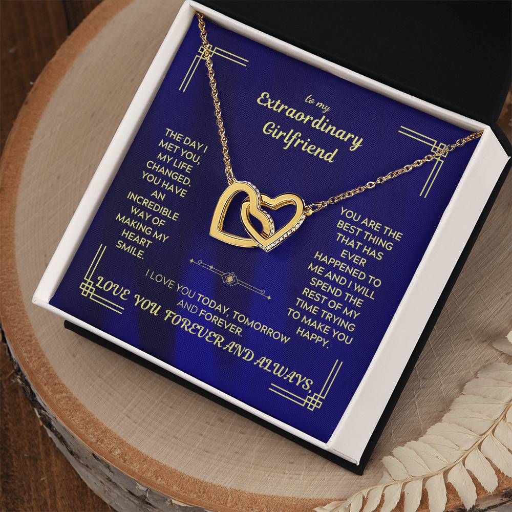 Interlocking hearts necklace with blue enamel message card and gold-tone heart pendant.