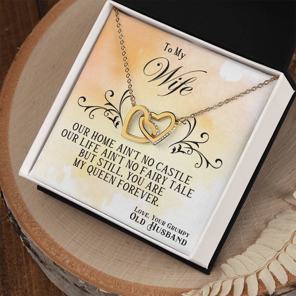 Heart pendant necklace in open gift box on a wooden tray, silver chain visible
