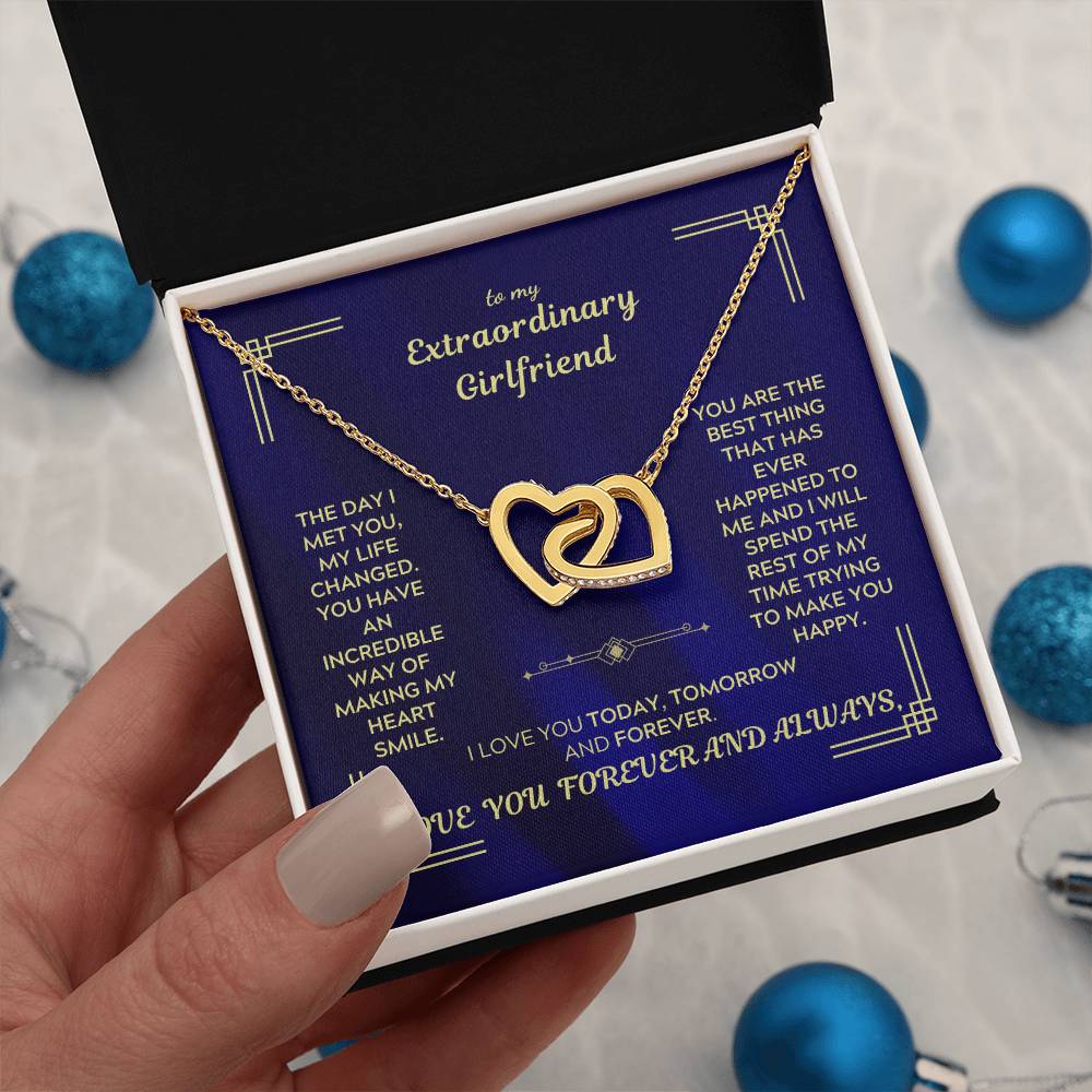 Interlocking hearts necklace with gold-tone chain and double heart pendant on blue message card.