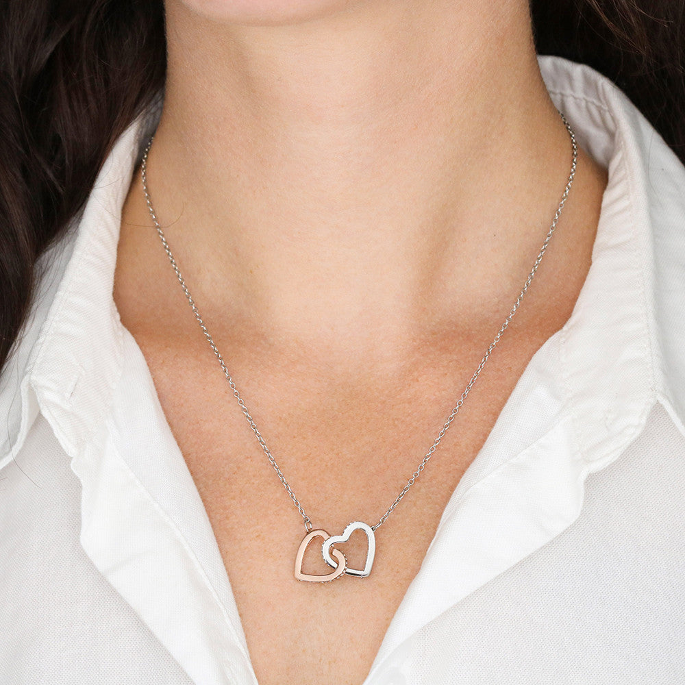 Heart pendant necklace on a person’s neckline with a silver-tone heart charm