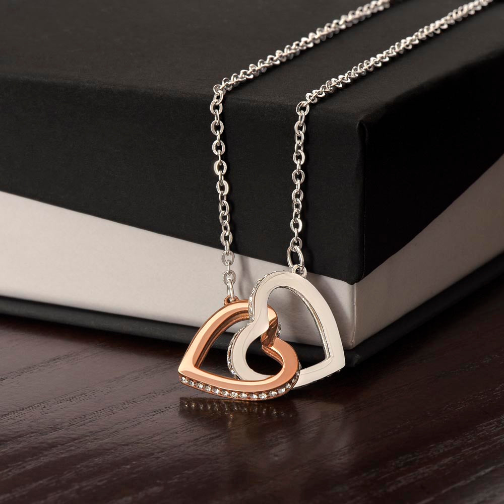 Interlocking hearts pendant on silver-tone chain, rose-and-gold heart accents with sparkle
