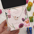 Heart pendant necklace with silver tone and rose-gold center, shown in open box