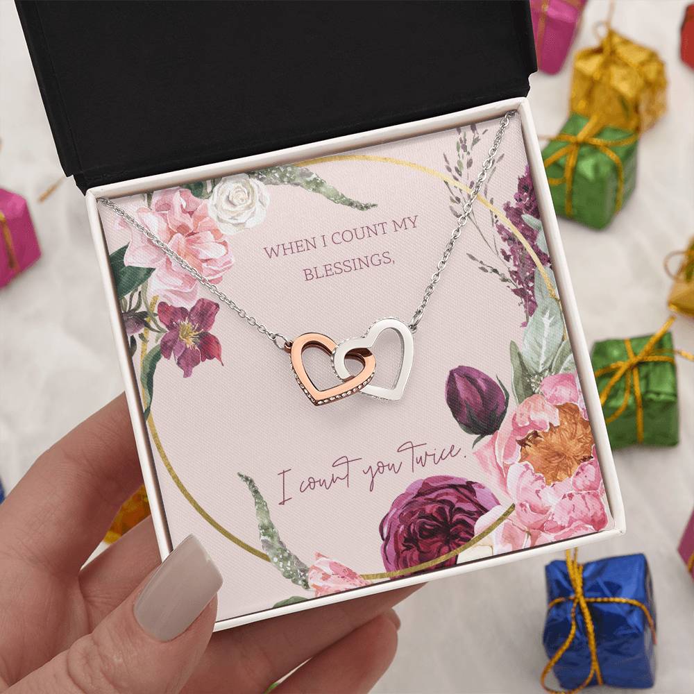 Heart pendant necklace with silver tone and rose-gold center, shown in open box