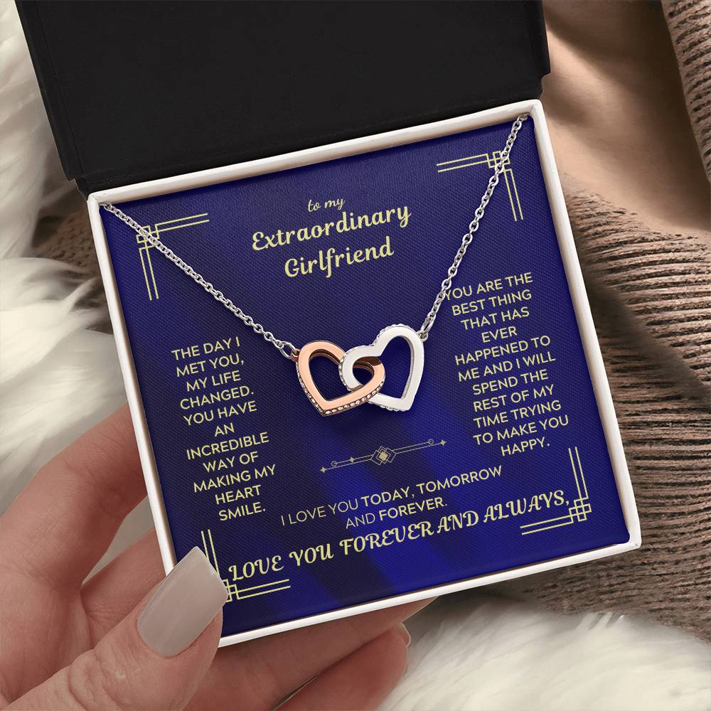 Interlocking hearts necklace with silver-tone chain and heart pendant on blue message card.