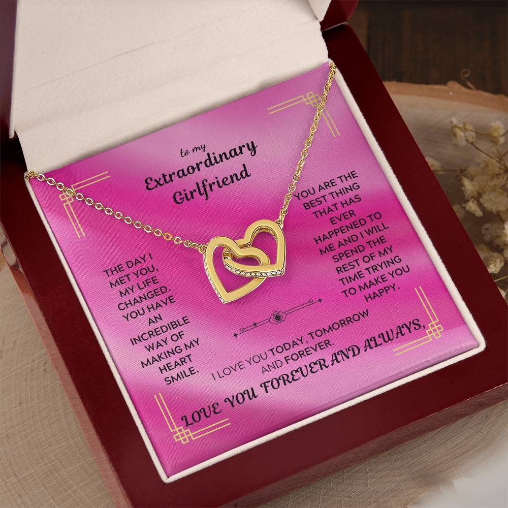 Gold interlocking hearts pendant necklace in a gift box on a pink card