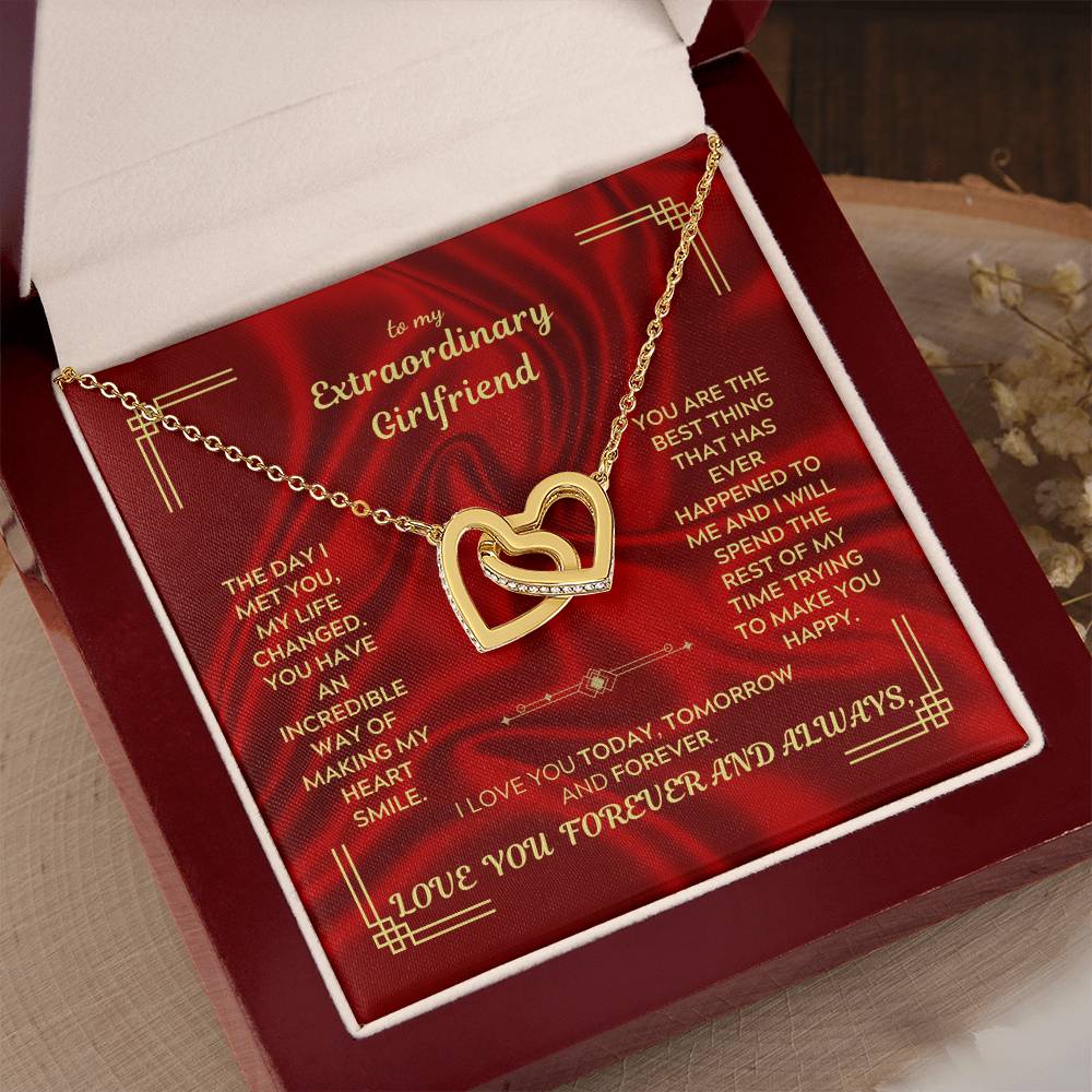 Gold-tone interlocking heart pendant necklace displayed in a red gift box