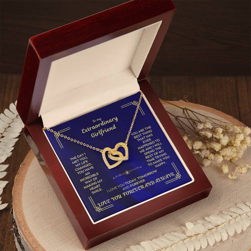 Interlocking hearts necklace in a red gift box with blue message card and heart pendant.