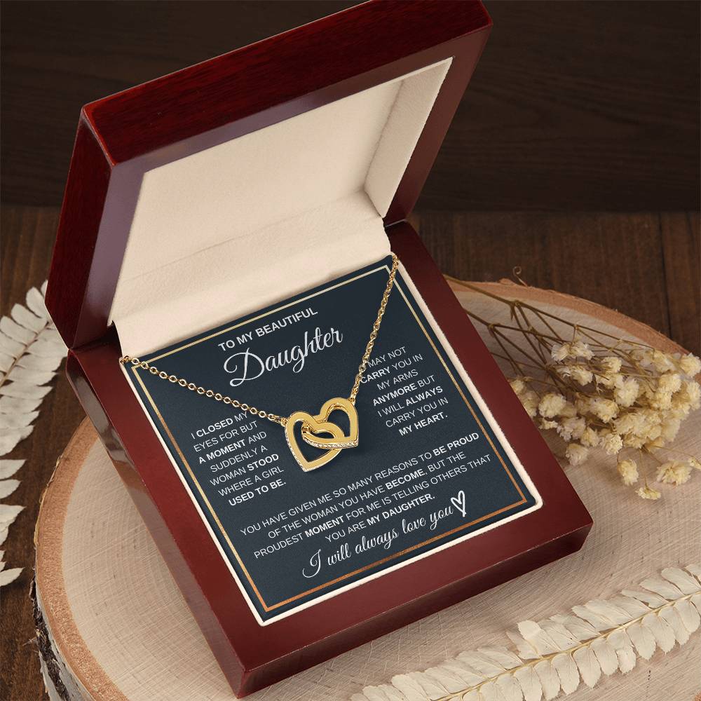 Gold heart pendant necklace with chain inside gift box, shown on display tray