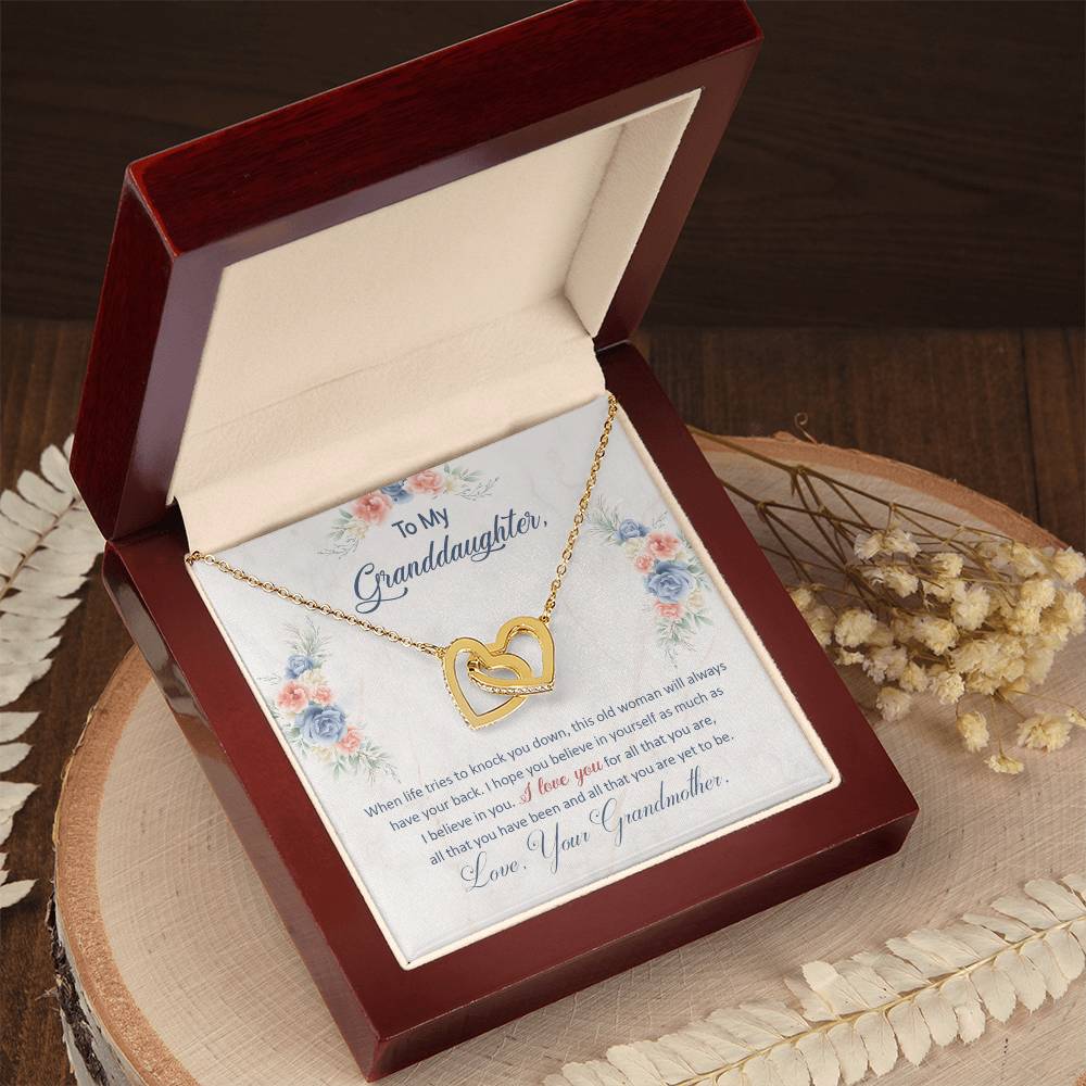 Heart pendant necklace in an open red gift box on a wooden tray