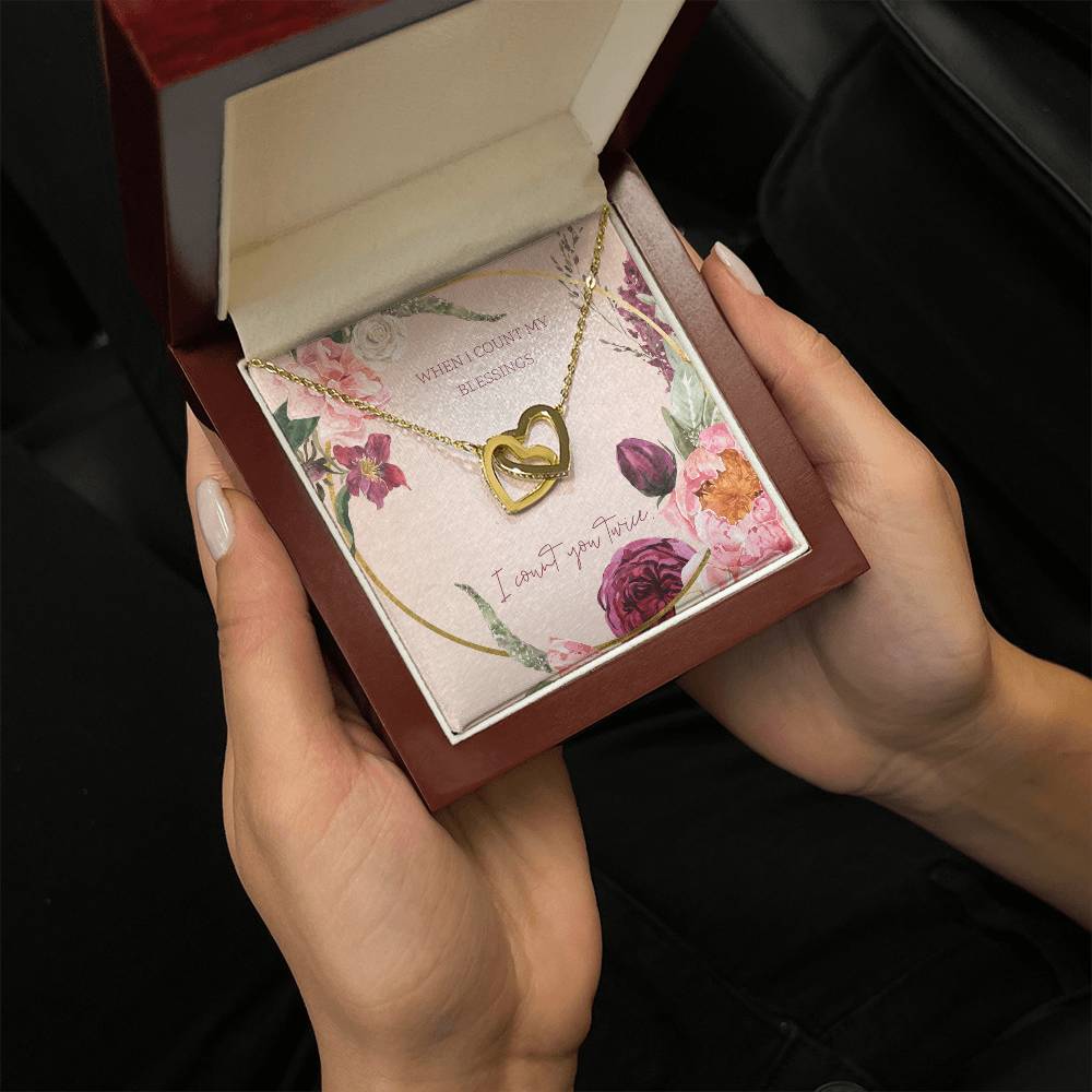 Gold-tone heart pendant necklace displayed in rose-toned gift box