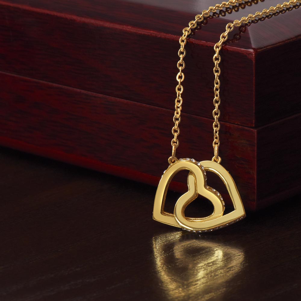 Gold-tone interlocking heart pendant on a chain necklace with link-style connector