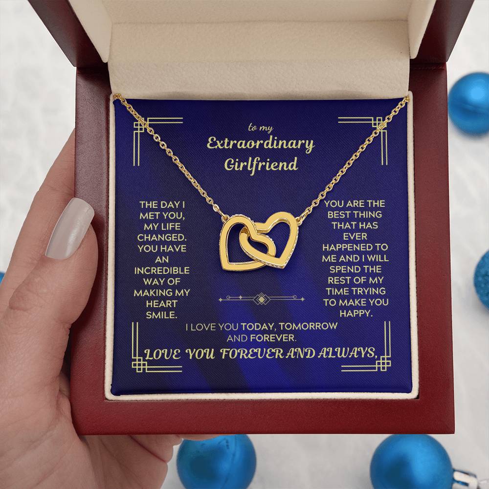 Gold-tone heart pendant necklace on chain inside blue gift box, held in hand