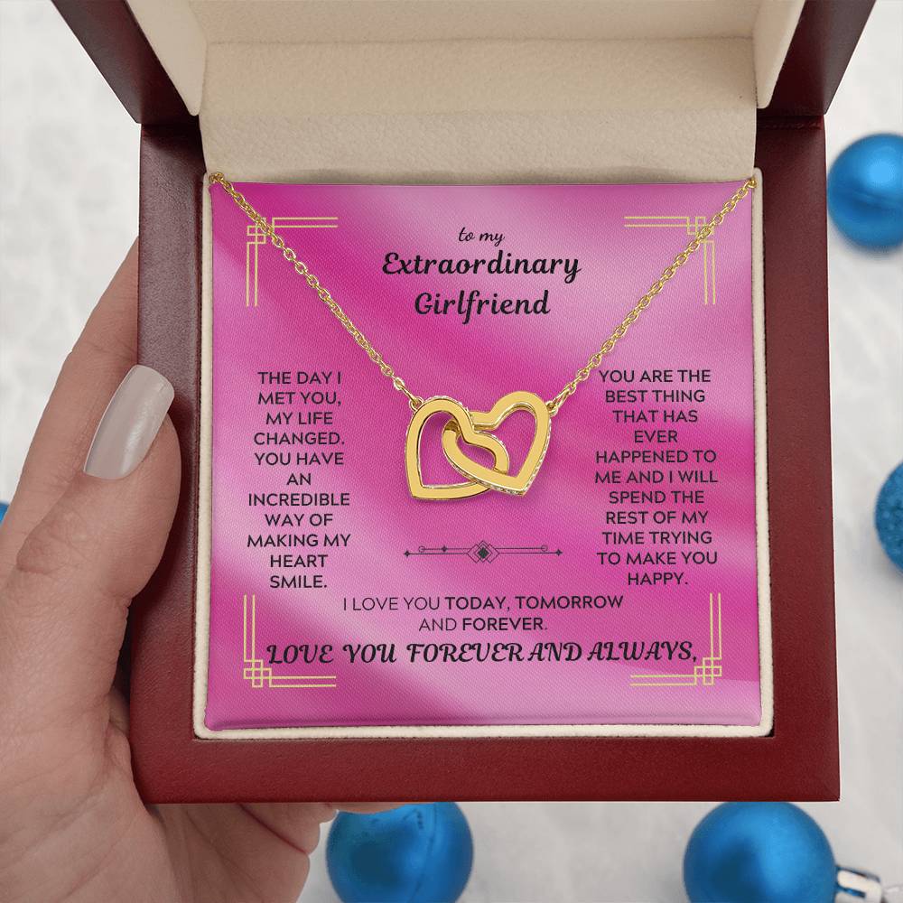 Gold interlocking hearts pendant necklace in an open gift box with a pink card