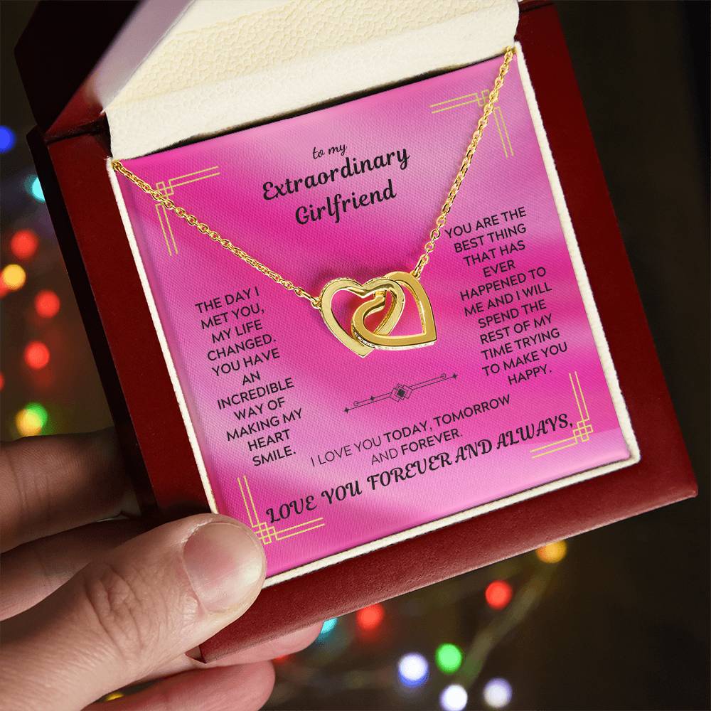 Gold interlocking hearts pendant necklace on a pink gift card inside a box