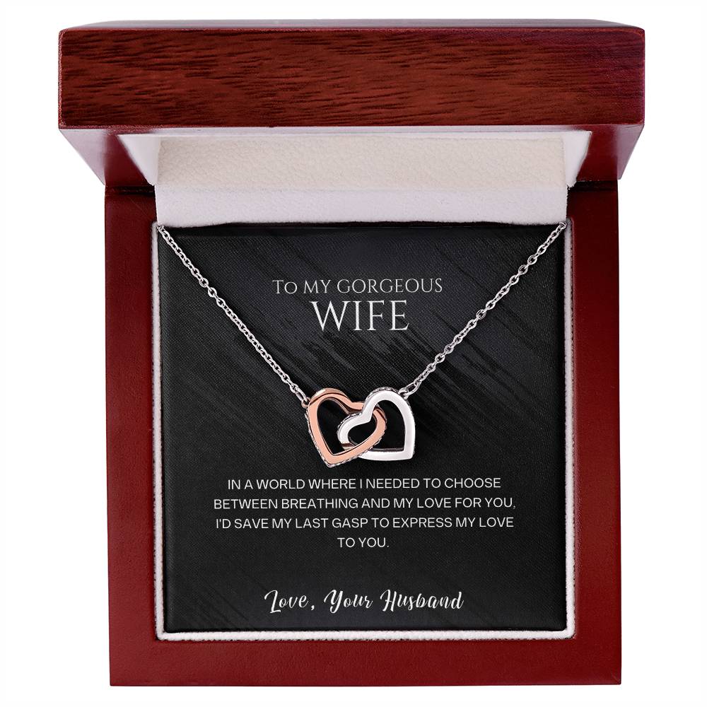 Silver-tone heart pendant necklace resting in a red gift box with cushion.