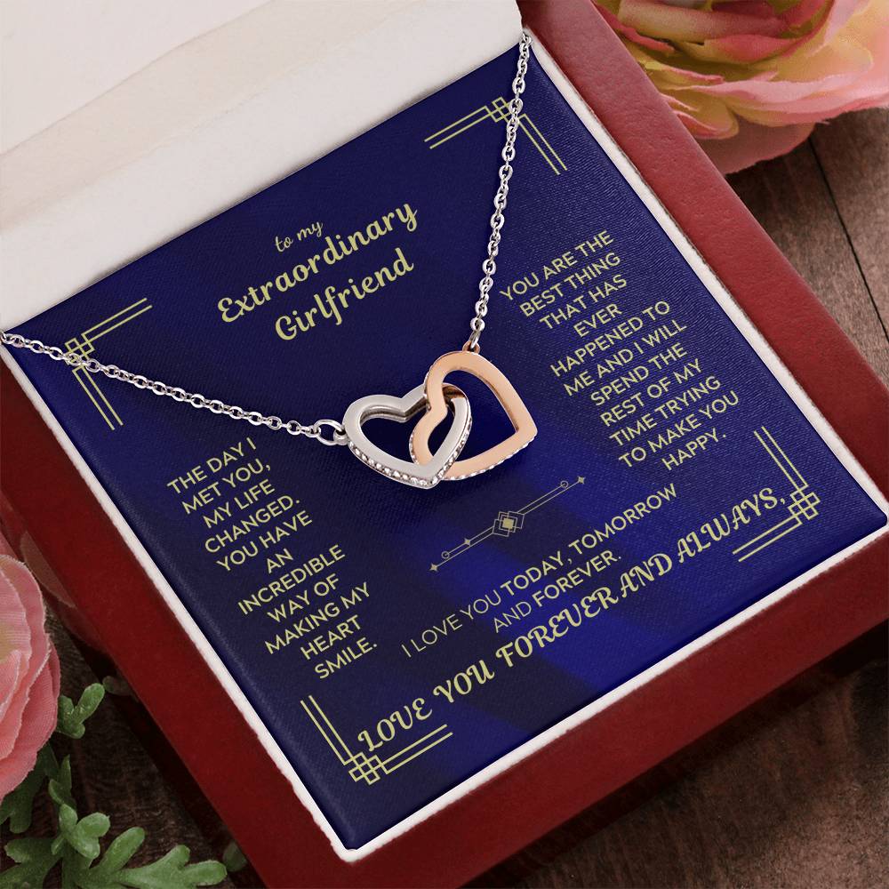 Interlocking hearts necklace with silver-tone chain and heart pendant on blue message card.
