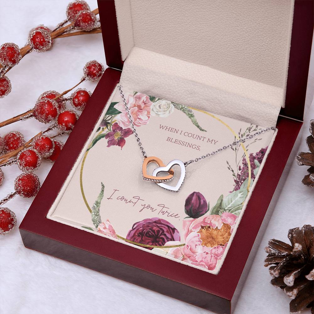 Heart pendant necklace with rose-gold center and silver frame inside gift box