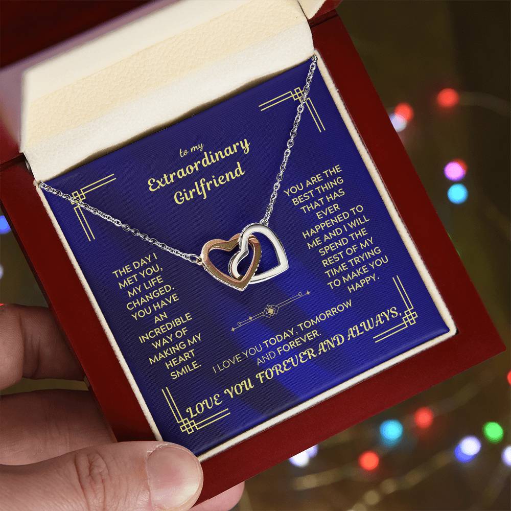Interlocking hearts necklace with gold-tone chain and heart pendant on blue message card.