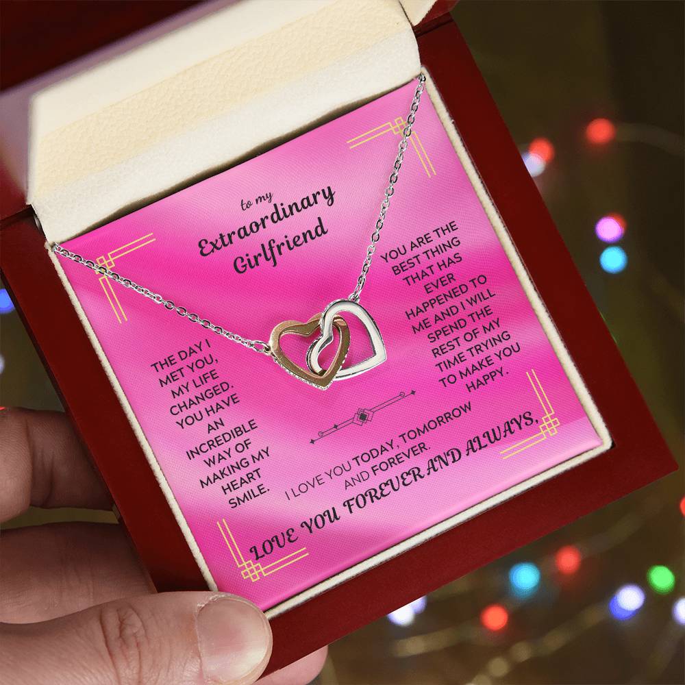 Rose-gold tone interlocking hearts pendant necklace with chain, shown on a gift box