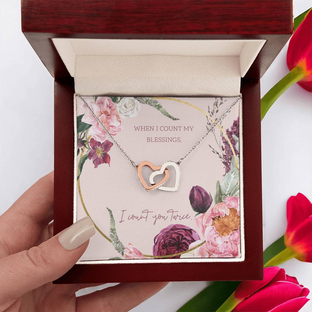 Heart pendant necklace with rose-gold center and silver chain, in red box