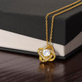 Love knot necklace with gold-tone chain and round crystal heart-knot pendant