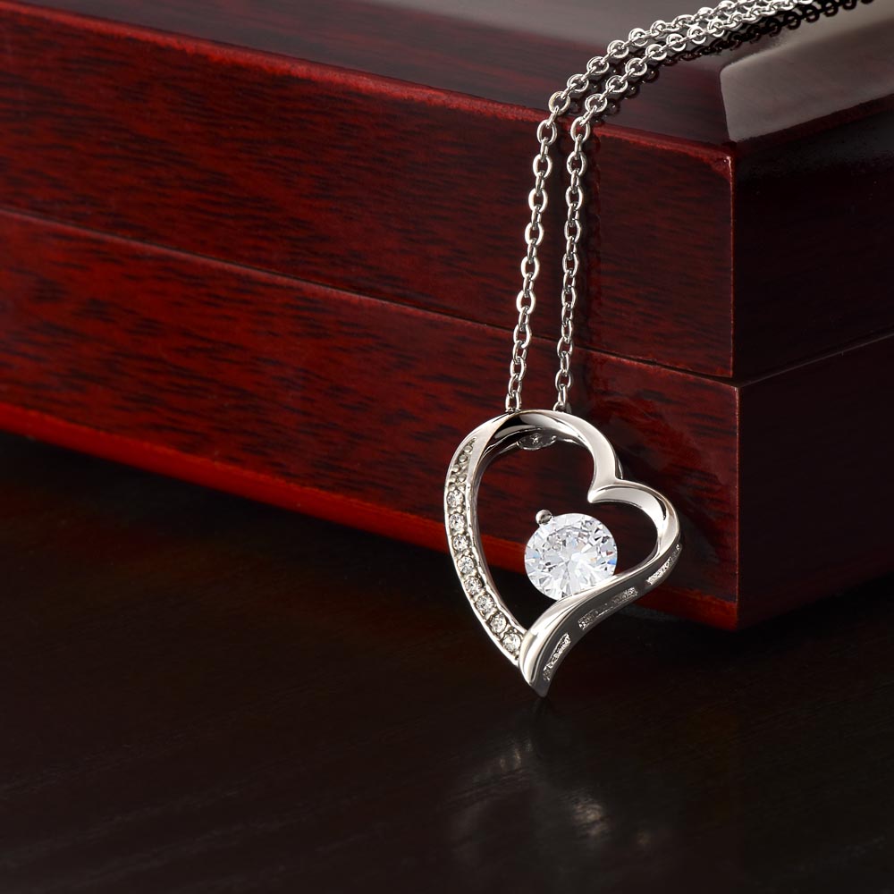 Silver-tone heart pendant necklace with round center stone and pavé set outer heart.