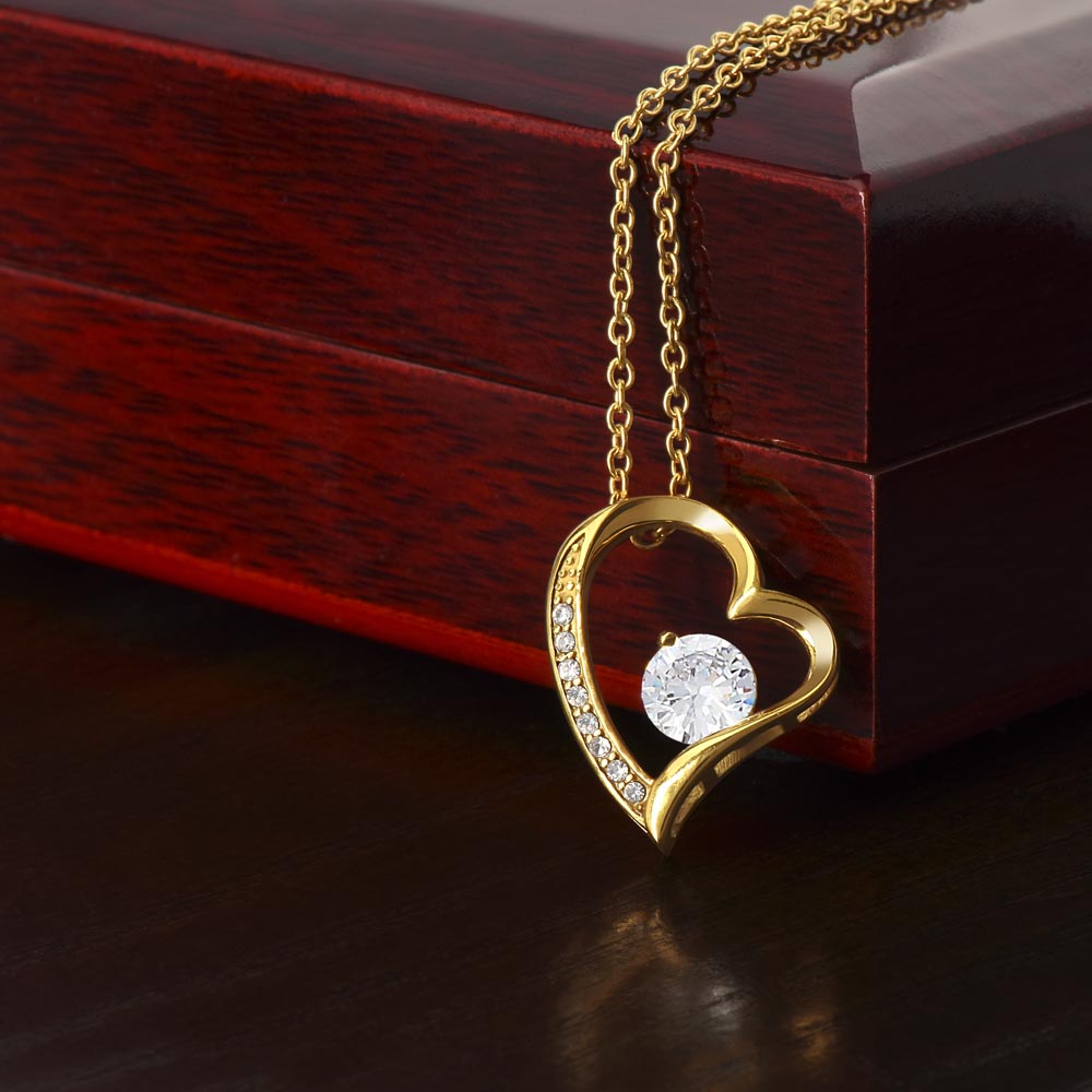 Gold-tone heart pendant necklace with round center stone and pavé set outer heart.