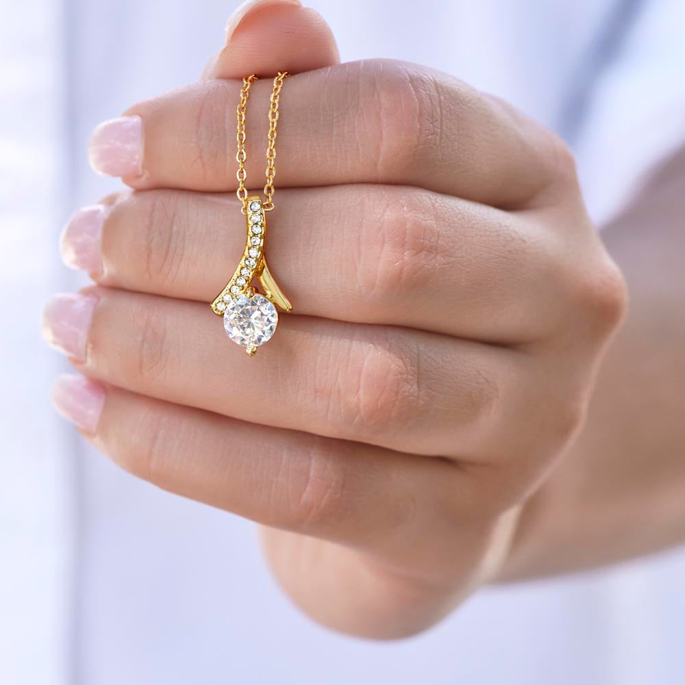 Gold-tone necklace with teardrop pendant and round sparkling stone