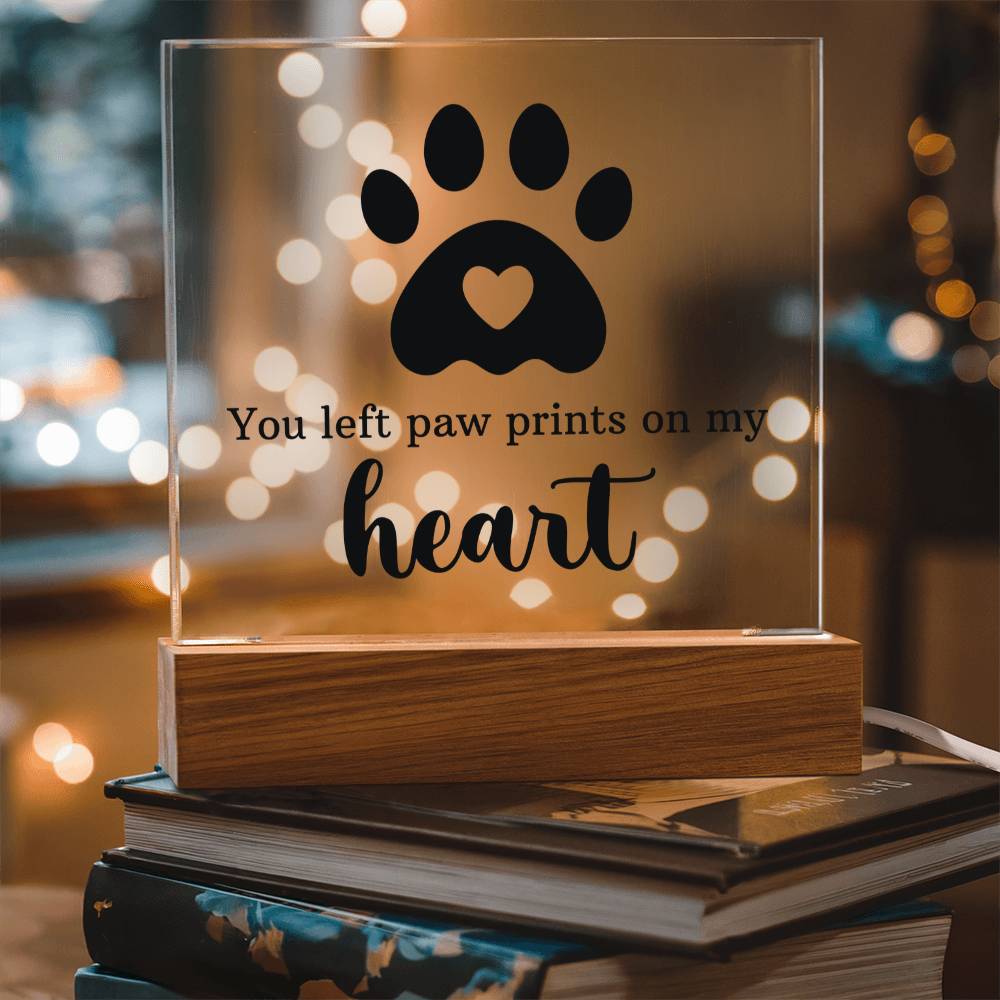 Acrylic keepsake with paw-print heart design and wooden base, warm glowing interior