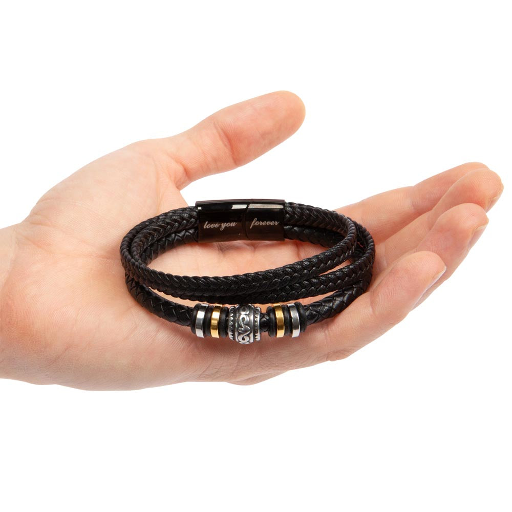 Black braided bracelet with gold and silver metal spacers held in an open palm.