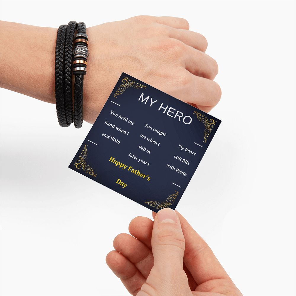 Black braided wrap bracelet on wrist with dark greeting card reading 'My Hero'