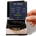Black braided vegan leather bracelet with gold and silver bead accents, engraved clasp