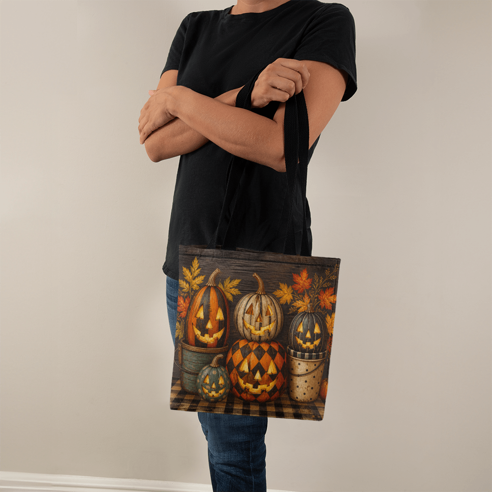 Black-handled Halloween canvas tote bag held in hand, pumpkin and plaid design