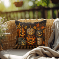 Halloween throw pillow with dark cover showing stacked pumpkins and fall leaves
