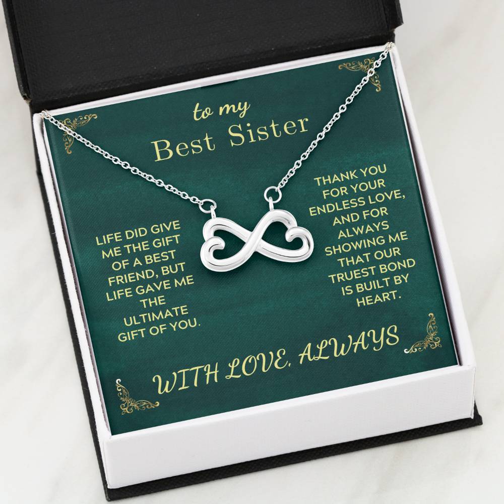 Open green gift card box with heart infinity pendant necklace inside.