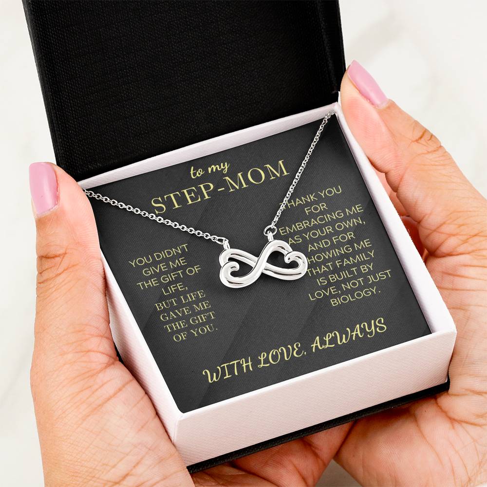 Silver infinity heart pendant necklace in a black gift box held by hands