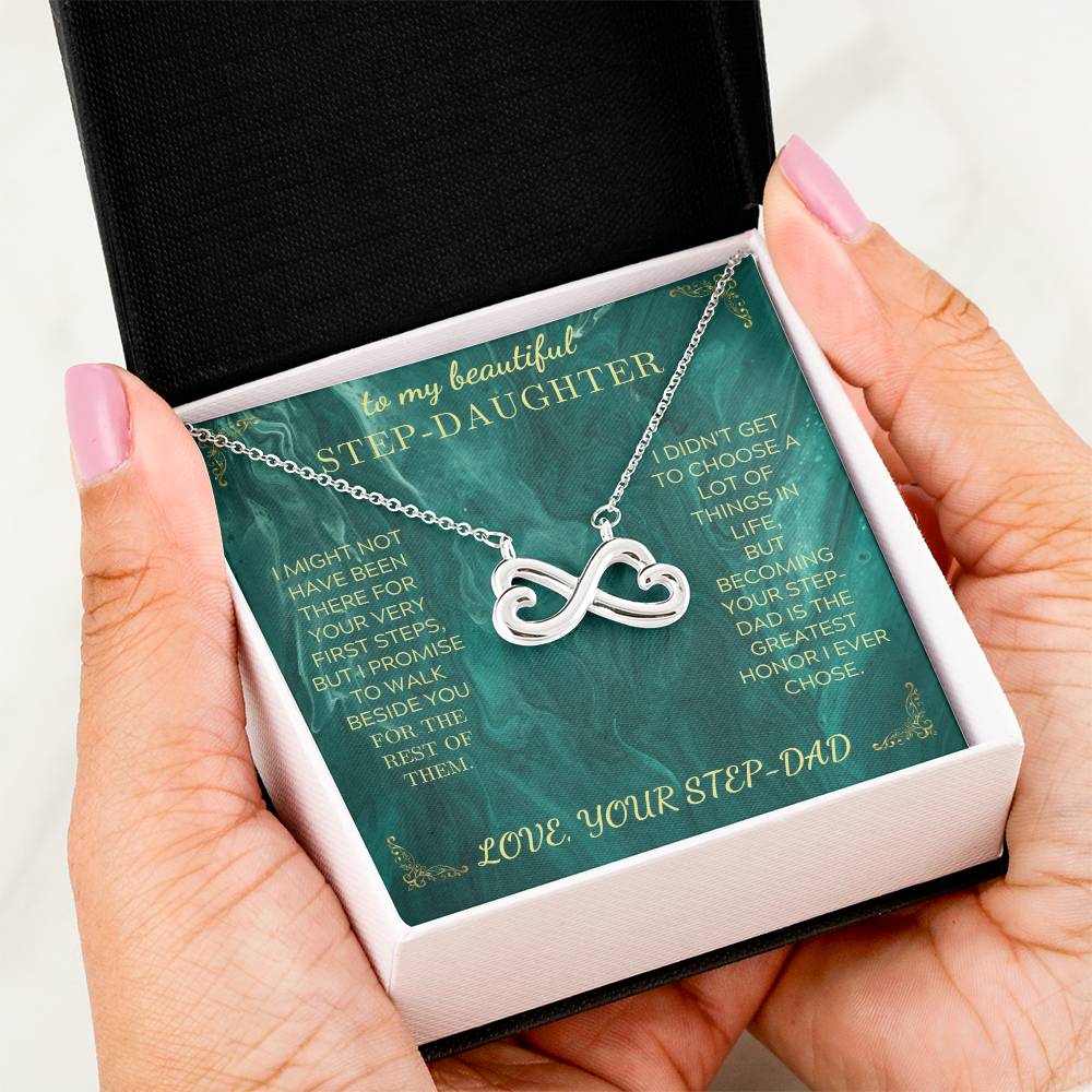 Silver heart infinity pendant necklace on green message card, shown in a hand
