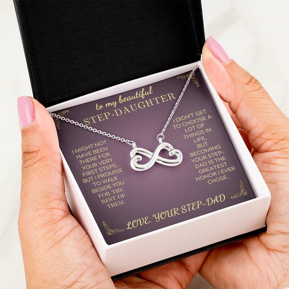 Silver-tone infinity heart pendant necklace in purple gift box, shown in a hand
