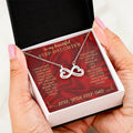 Hand holding open necklace gift box with heart-infinity pendant necklace and card