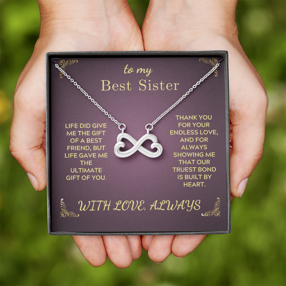 Infinity heart pendant necklace on purple gift card, silver-tone chain in hand