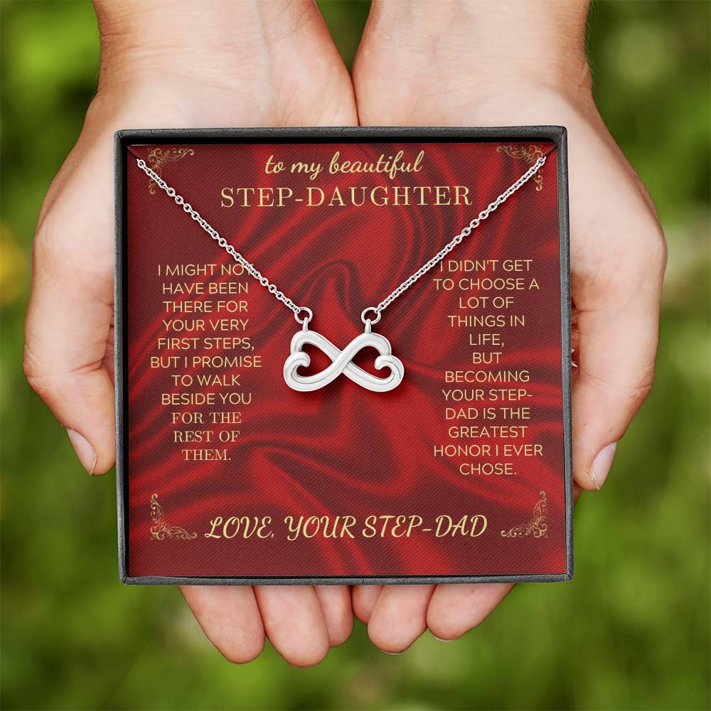 Hand holding red gift box with silver heart-infinity pendant necklace and message card