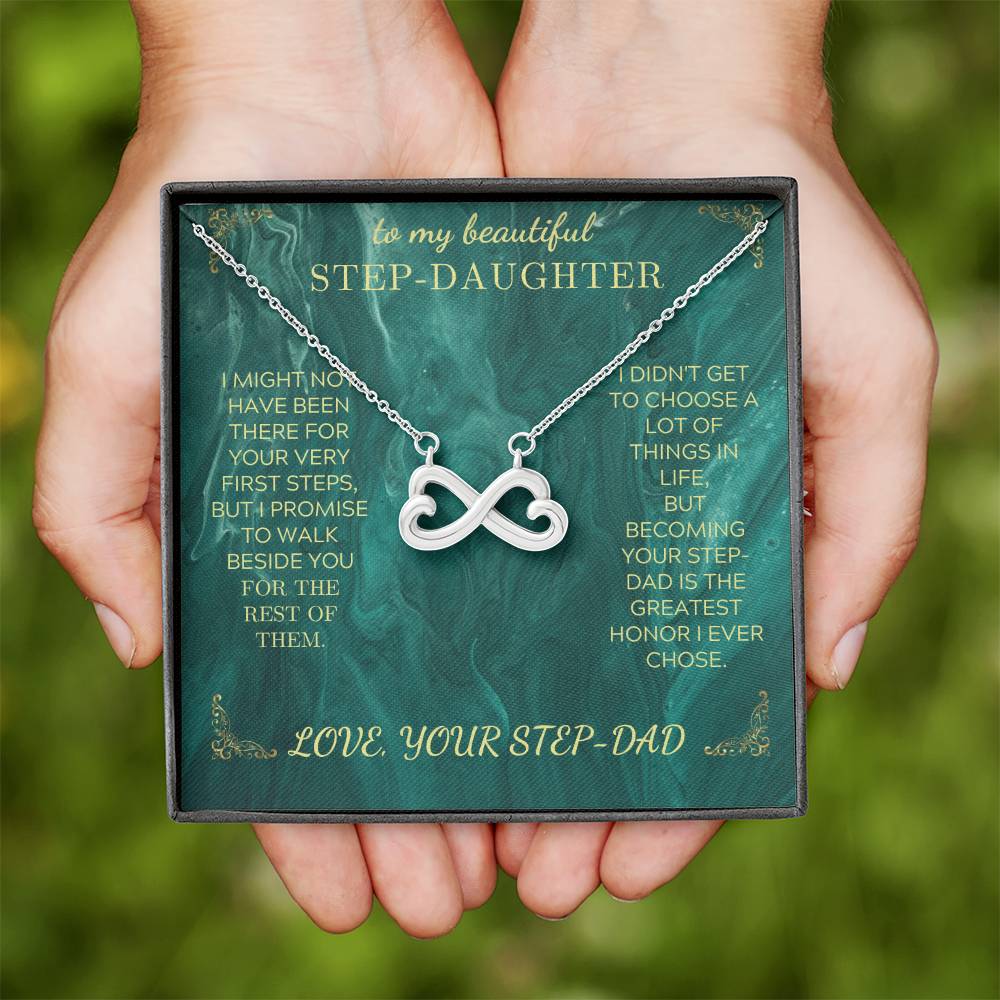 Silver heart infinity pendant necklace on green message card held in a pair of hands