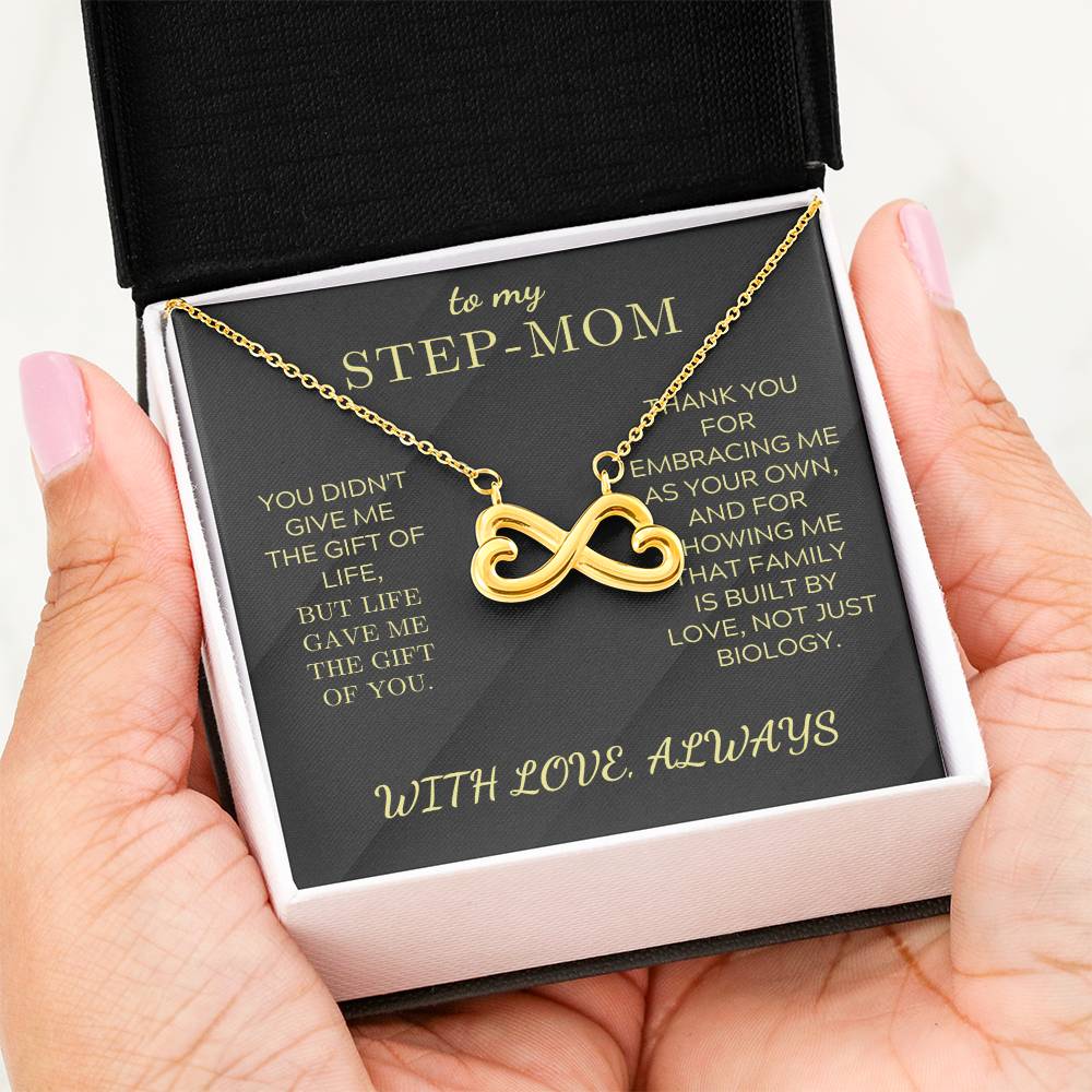 Gold infinity heart necklace in a gift box, “STEP-MOM” card with “WITH LOVE, ALWAYS”