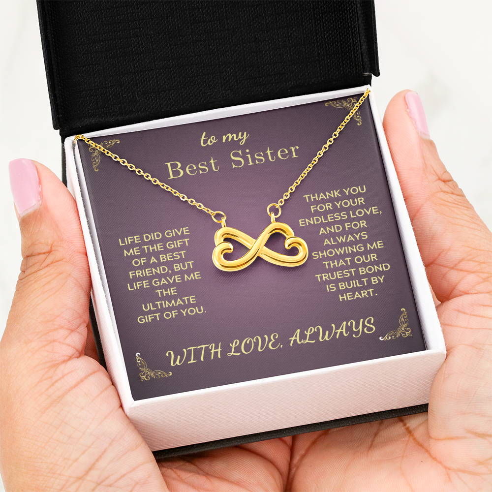 Gold-tone infinity heart pendant necklace on purple gift card in box, golden chain