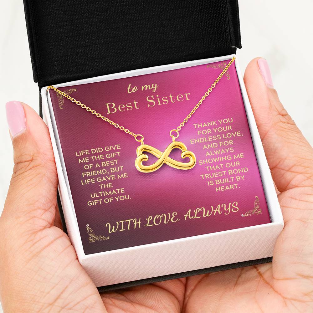 Gold-tone infinity-heart necklace in gift box held in hands