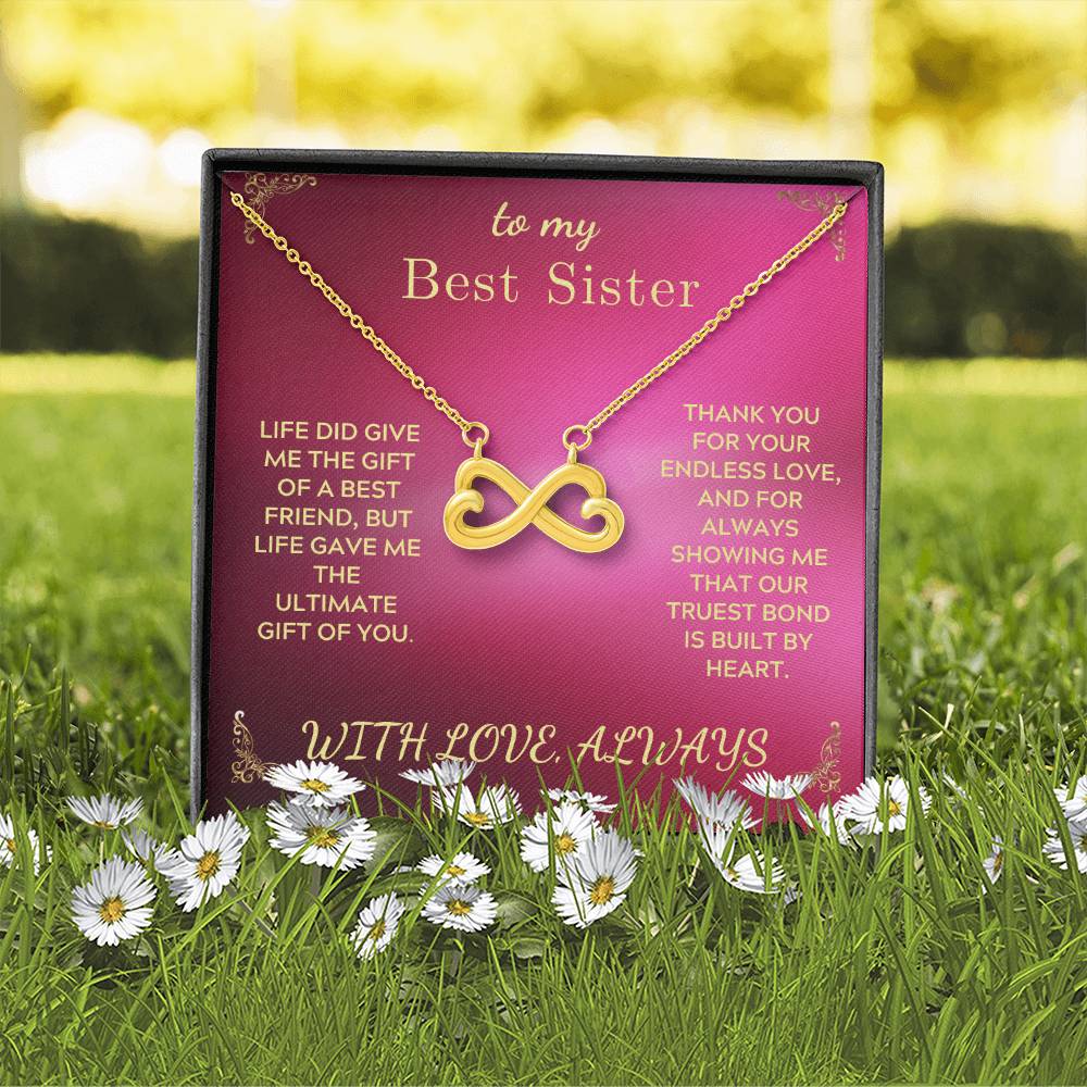 Silver-tone infinity heart pendant necklace gift box on grass with dangling chain
