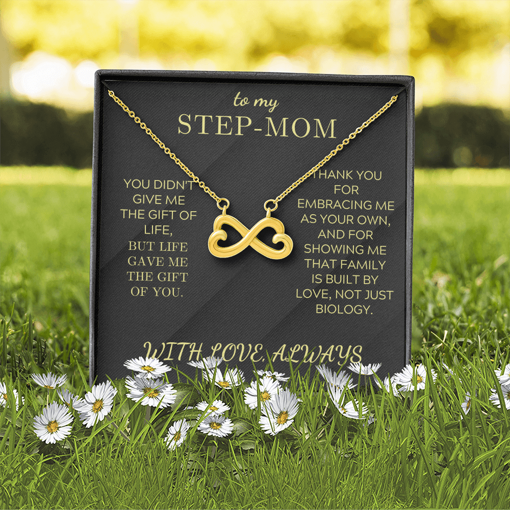 Gold infinity heart pendant necklace in a black gift box outdoors