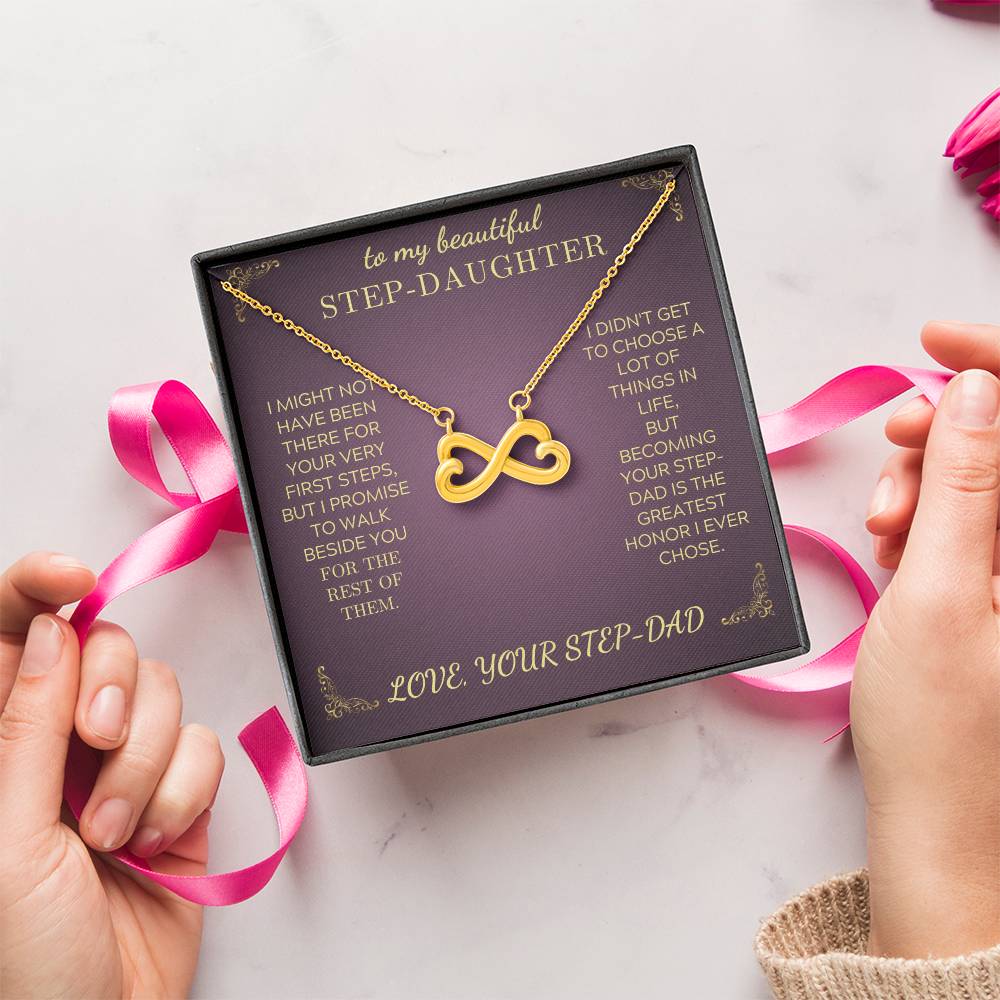Gold infinity heart pendant necklace shown on a purple gift box