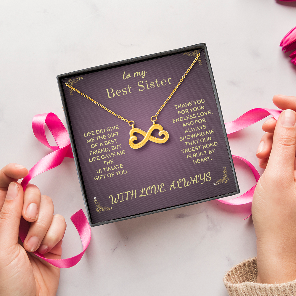 Gold-tone infinity heart pendant necklace on purple gift card with pink ribbon