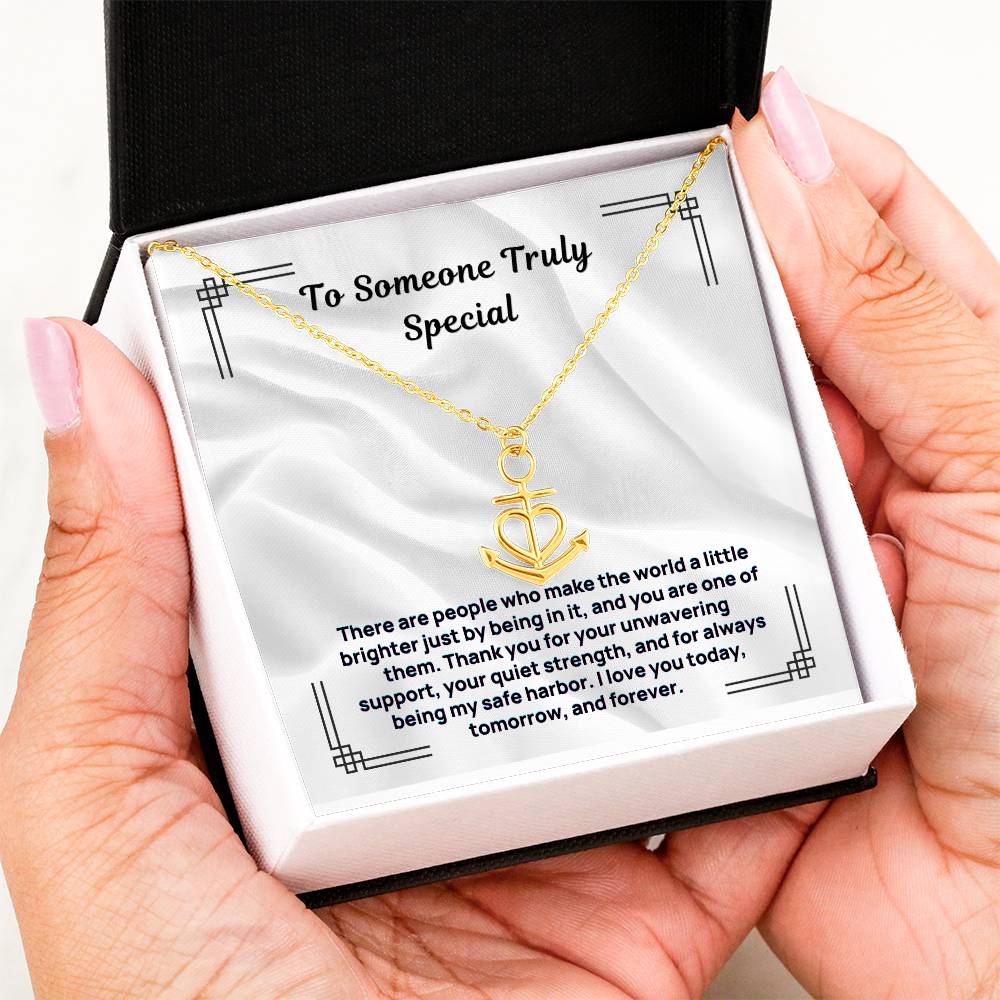 Gold-tone anchor heart pendant necklace in open box held in hands